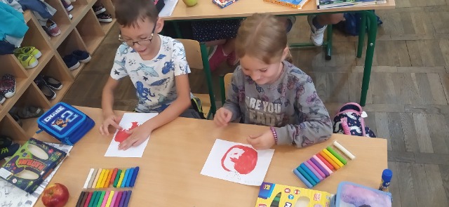 Uczniowie klasy 1a wyklejają z plasteliny prace plastyczne pt."Jabłka".