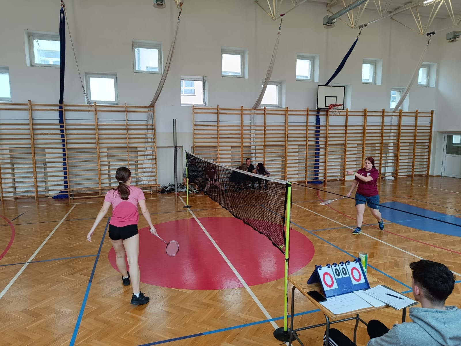 Mecz między dziewczętami w badmintona na sali gimnastycznej