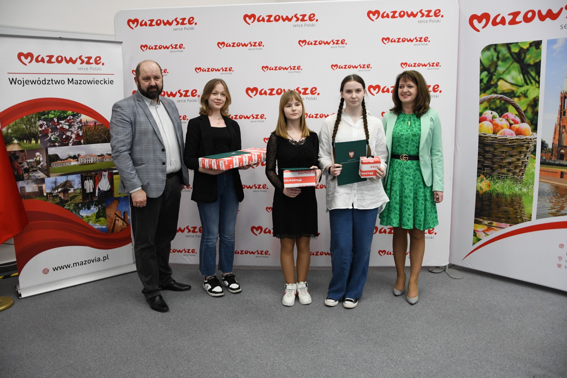 Laureaci konkursu wraz z organizatorami na tle ścianki z napisem "Mazowsze - serce Polski"
