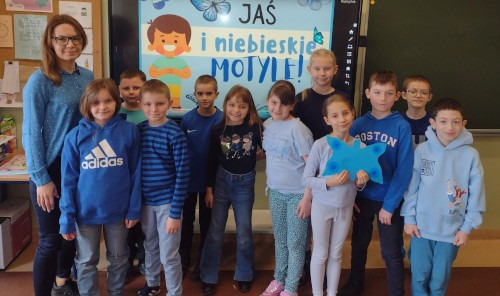 Uczniowie ubrani na niebiesko wraz z wychowawczynią