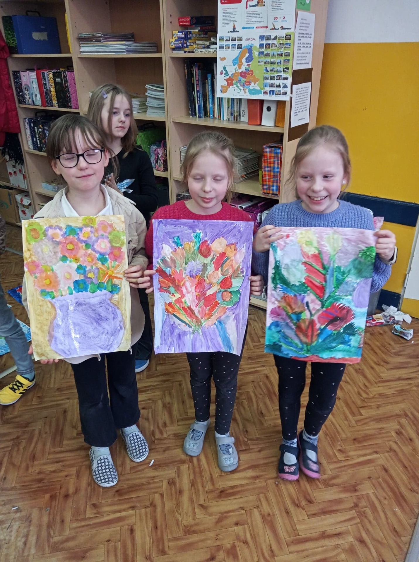 Dziewczynki prezentują swoje namalowane kwiaty