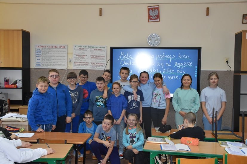 Grupa uczniów w niebieskich strojach jako symbol udział w obchodach Międzynarodowego Dnia Praw Dziecka.