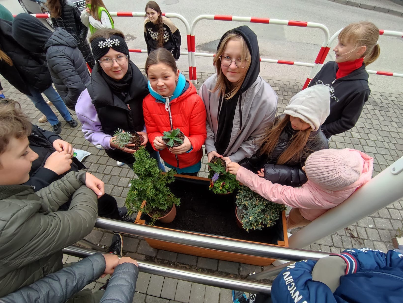 Grupa dzieci sadzi rosliny