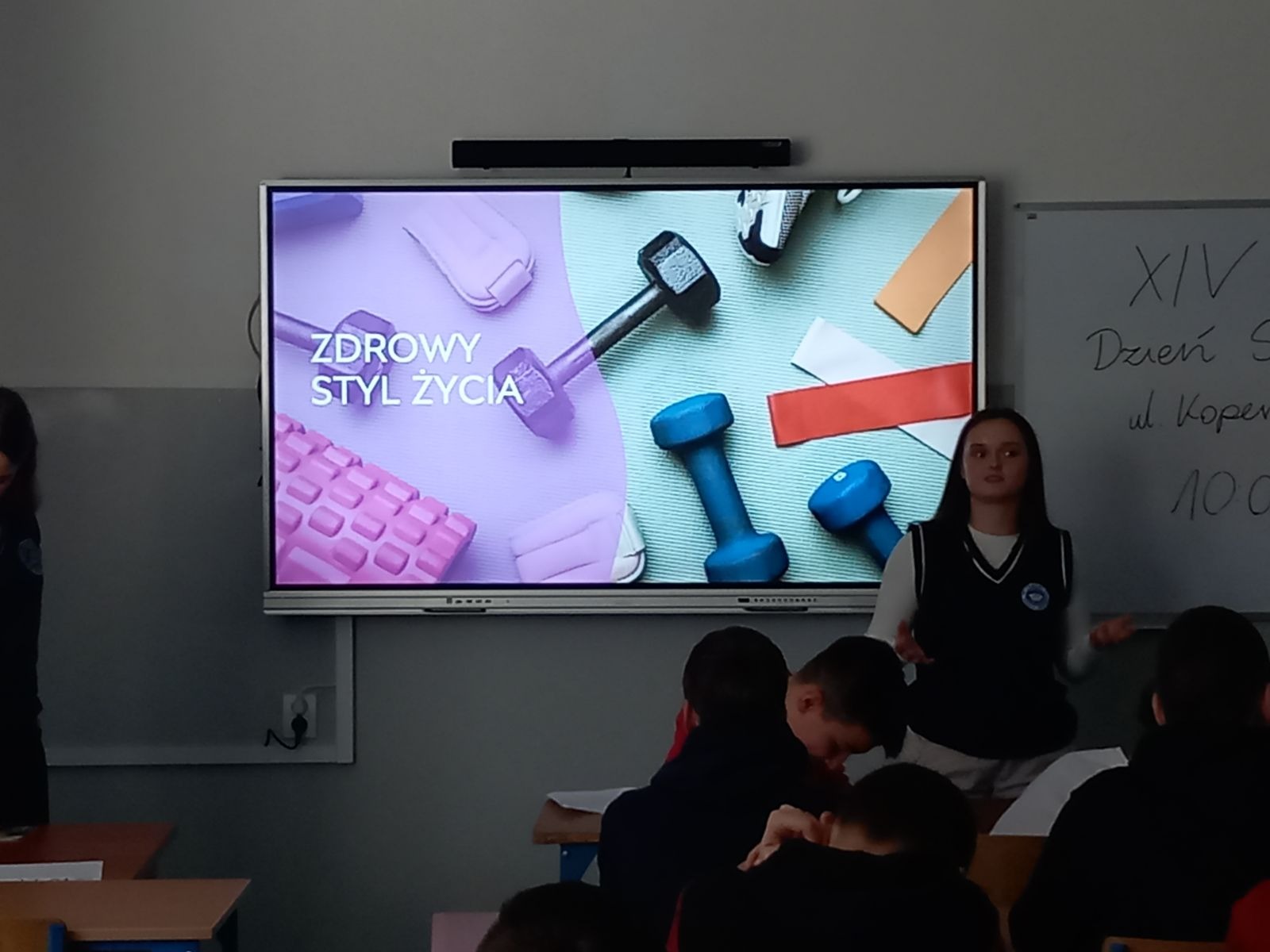 Uczennica Liceum XIV prezentuje program na monitorze interaktywnym.