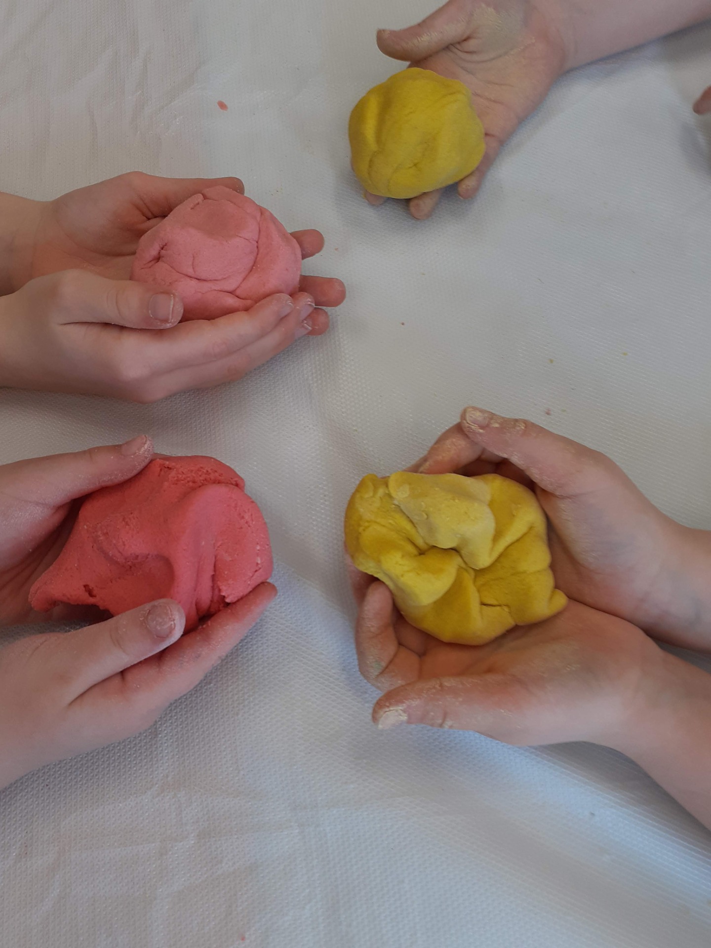 Dzieci w dłoniach z różnymi kolorami masy solnej